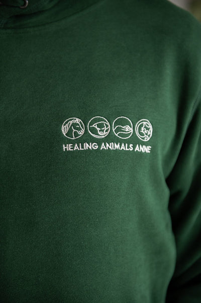 Geborduurd logo Healing Animals op een groene sweater